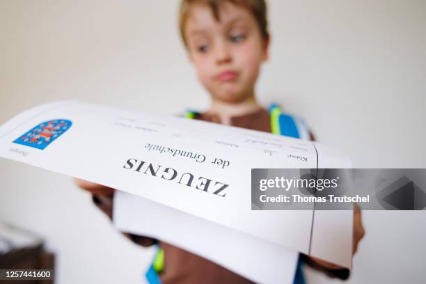 Symbolic photo on the subject of testimonials in elementary school. A boy poses with a certificate on May 19, 2023 in Berlin, Germany.