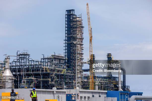 Construction crane alongside a stack tower at the Dangote Industries Ltd. Oil refinery and fertilizer plant site in the Ibeju Lekki district of...