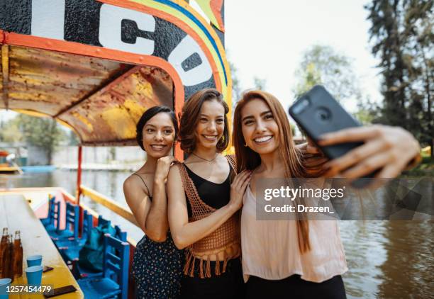 latin travelers on city break enjoying boat ride - xochimilco stock pictures, royalty-free photos & images