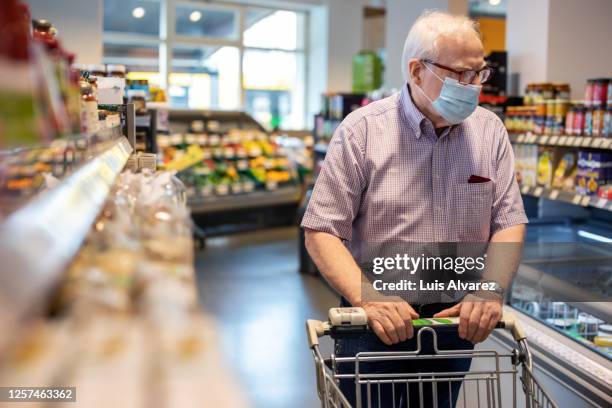 senior man shopping in local supermarket - panic buying stock pictures, royalty-free photos & images