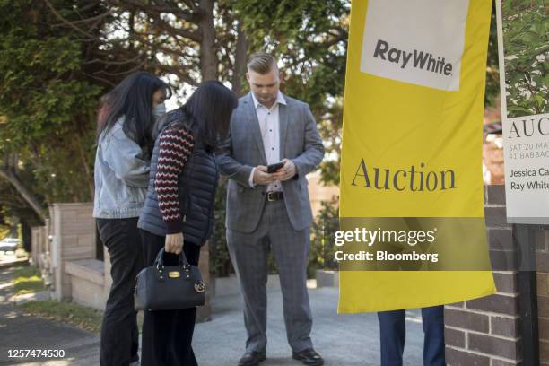 Women arrive at an auction of a property in Sydney, Australia, on May 20, 2023. In Australia, it's never been harder for people to get on the housing...