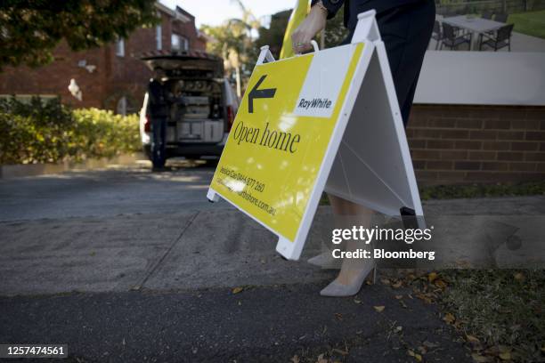 Real estate agent carries an open home sign before an auction of a property in Sydney, Australia, on May 20, 2023. In Australia, it's never been...