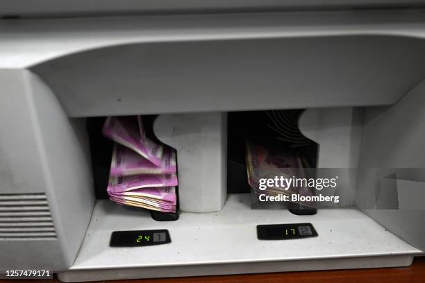 Rupee banknotes in a currency counting machine at a bank in New Delhi, India, on Tuesday, May 23, 2023. India withdrawing its highest value currency...