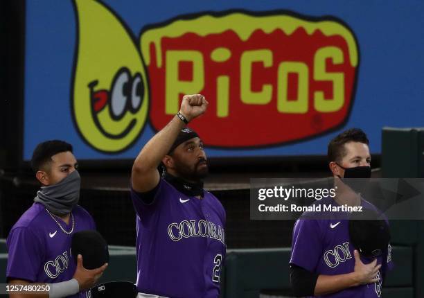 Matt Kemp of the Colorado Rockies raises a fist as the national anthem is played before a MLB exhibition game against the Texas Rangers at Globe Life...
