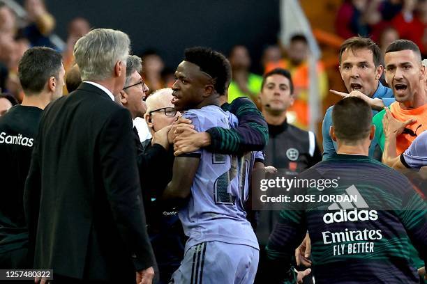 Real Madrid's Brazilian forward Vinicius Junior confronts Valencia's officials as he leaves after being sent off the pitch by the referee during the...