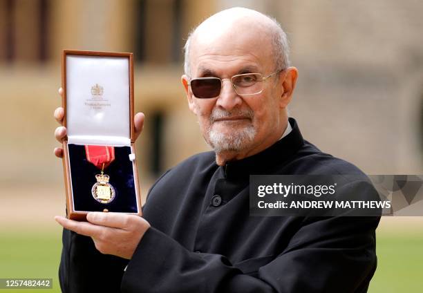 British author Salman Rushdie poses with their medal after being appointed as a Member of the Order of the Companions of Honour during an investiture...