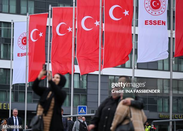 Turkish voters living in Germany take pictures of themselves in front of Turkish flags outside a polling station set up in the Grugahalle hall in...