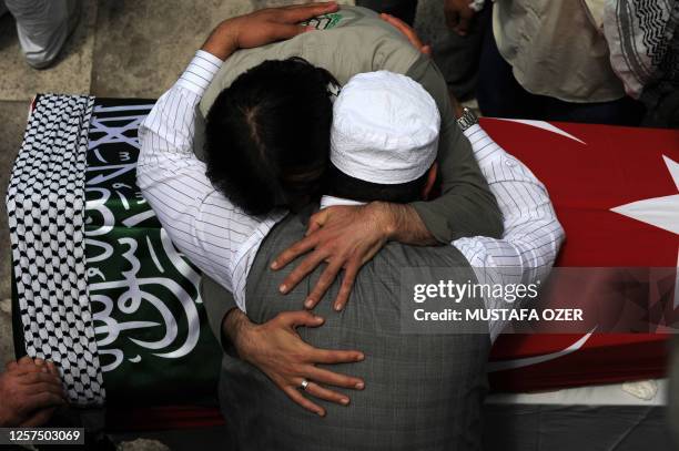 Relatives embrace over the coffin of one of the victims of Israel's deadly raid on aid ships bound for Gaza at the Fatih Mosque in Istanbul on June...