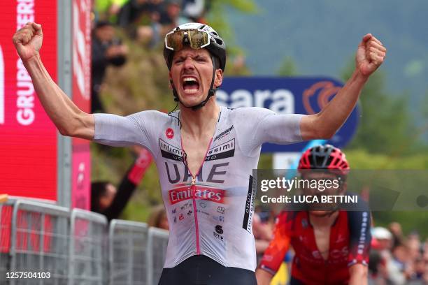 Team Emirates's Portuguese rider Joao Almeida celebrates as he crosses the finish line to win the sixteenth stage of the Giro d'Italia 2023 cycling...