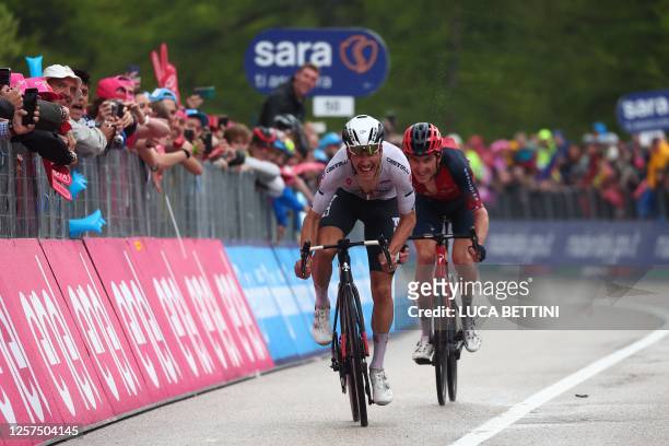 Team Emirates's Portuguese rider Joao Almeida sprints to win ahead of INEOS Grenadiers's British rider Geraint Thomas during the sixteenth stage of...