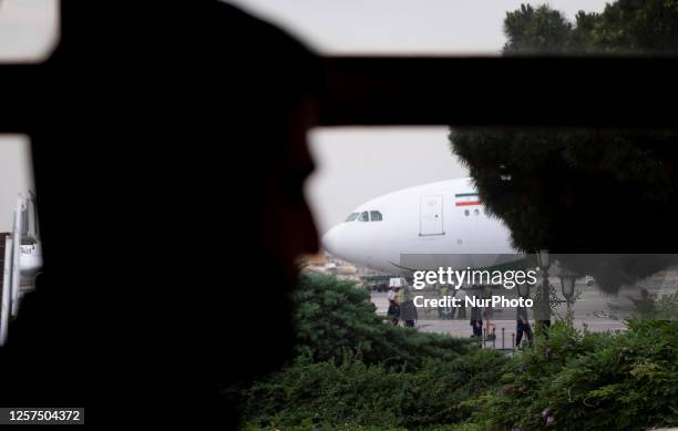 Security personnel stands guard next to an aircraft at Tehran's International Mehrabad Airport, during an official farewell ceremony, May 22, 2023.