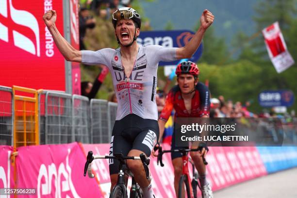 Team Emirates's Portuguese rider Joao Almeida celebrates as he crosses the finish line to win the sixteenth stage of the Giro d'Italia 2023 cycling...