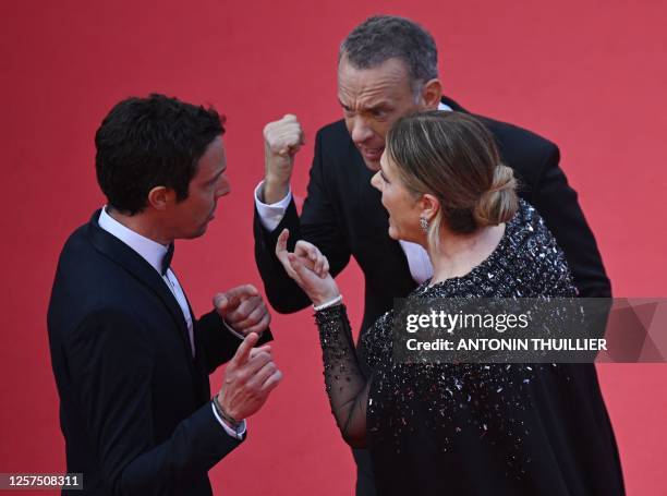 Actor Tom Hanks and US actress Rita Wilson speak with a staff member as they arrive for the screening of the film "Asteroid City" during the 76th...