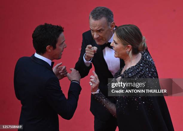 Actor Tom Hanks and US actress Rita Wilson speak with a staff member as they arrive for the screening of the film "Asteroid City" during the 76th...