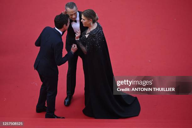 Actor Tom Hanks and US actress Rita Wilson speak with a staff member as they arrive for the screening of the film "Asteroid City" during the 76th...