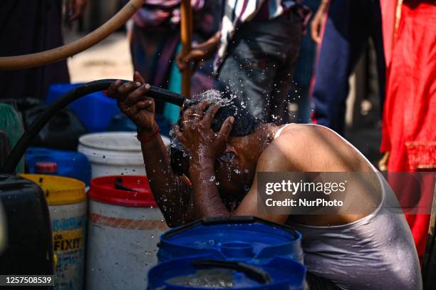 Man puts water on his head from a Municipal Water Tanker to cool himself outside a slum cluster on a hot summer day in New Delhi, India on May 23,...