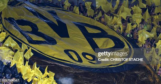 Dortmund's supporters display a large banner as they cheer for their team prior to the German first division Bundesliga football match between FC...