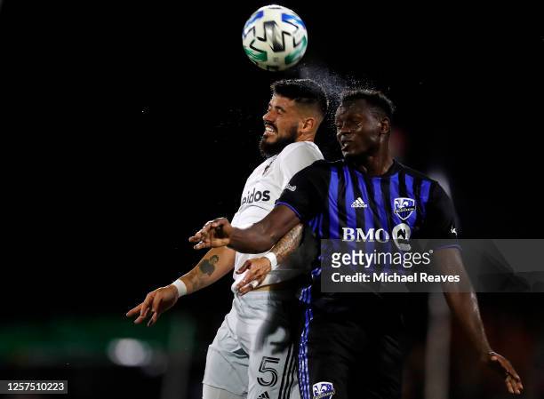 Junior Moreno of D.C. United and Victor Wanyama of Montreal Impact battle for a header during a Group C match as part of the MLS Is Back Tournament...