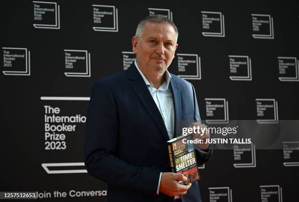 Bulgarian author Georgi Gospodinov poses with his book Time Shelter on the red carpet upon arrival for the International Booker Prize award ceremony,...