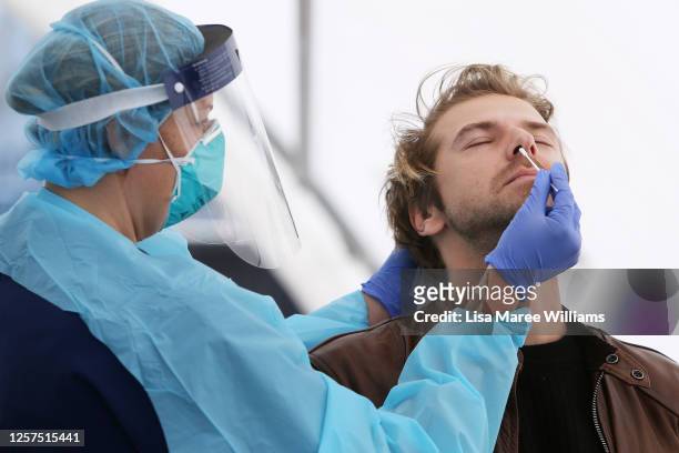Registered Nurse Michelle Gibbons conducts a COVID-19 swab test on a man at Bondi Beach on July 22, 2020 in Sydney, Australia. New South Wales...