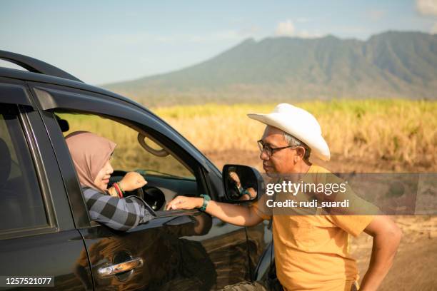 hiking couple is resting after long trekking in mountain - malay couple stock pictures, royalty-free photos & images
