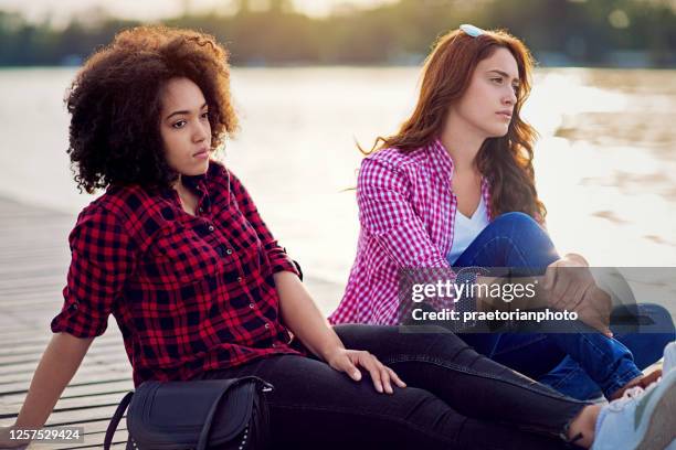 girlfriends are sulking each other along the lake - friends fighting stock pictures, royalty-free photos & images