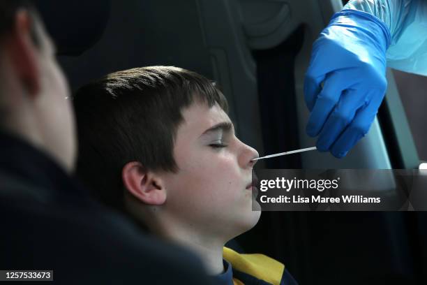 Registered Nurse Jade Spaven conducts a COVID-19 swab test on a boy at a Bondi Beach drive-through testing clinic on July 22, 2020 in Sydney,...