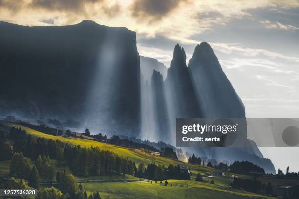 nebelfall - nebelberglandschaft mit sonnenstrahlen der seiser alm bei sonnenuntergang in dolomiten, italien - alm hütte stock-fotos und bilder