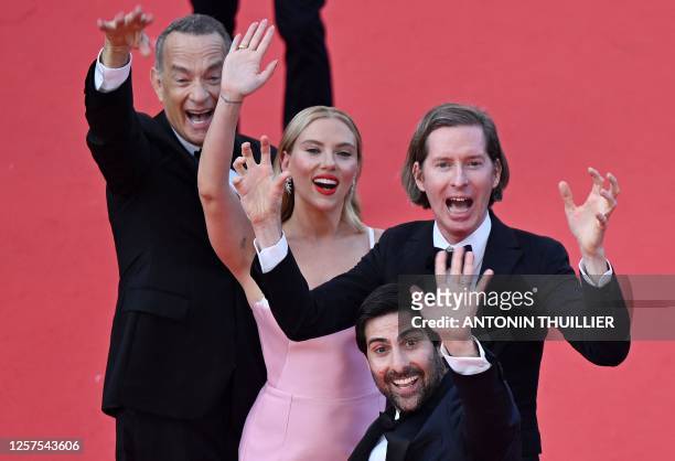 Actor Tom Hanks, US actress Scarlett Johansson, US film director Wes Anderson and US actor Jason Schwartzman wave as they arrive for the screening of...