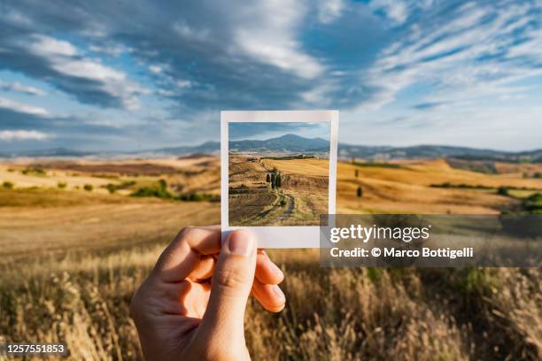 personal perspective of polaroid picture overlapping the tuscany landscape, italy - conceptual photography ストックフォトと画像