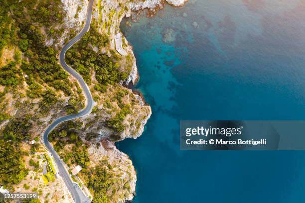 coastal road and deep blue sea along the amalfi coast, italy - costa caratteristica costiera foto e immagini stock