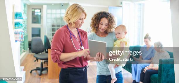 nieuwe patiënten in de kliniek - nurse ipad stockfoto's en -beelden