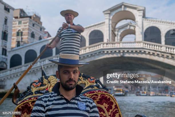 Father and son, both gondoliers, pose for a portrait in the Grand Canal on July 22, 2020 in Venice, Italy. A new rule in Venice will make becoming a...