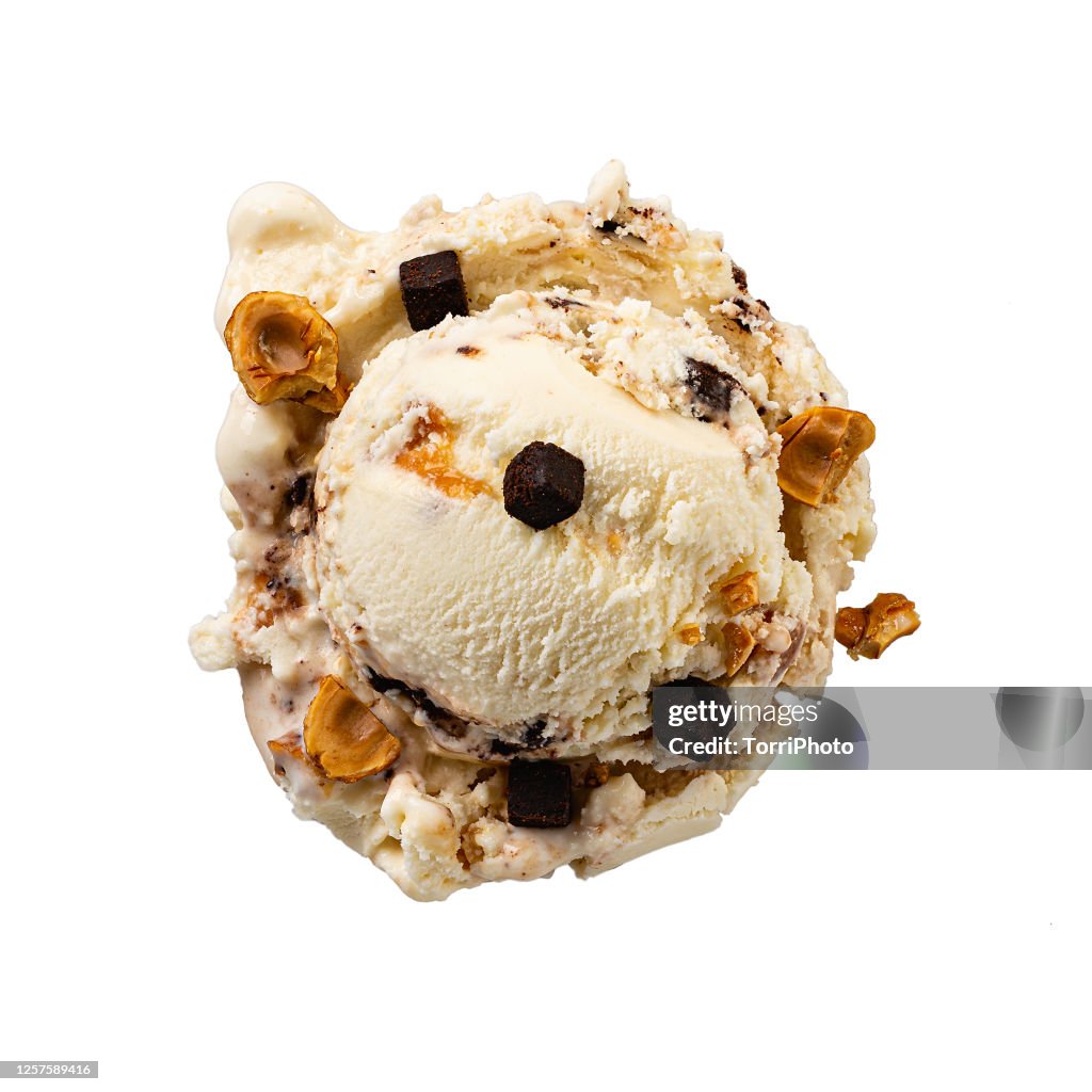 Top view of vanilla gelato scoop with caramel, hazelnuts and brownies crumbs isolated on white