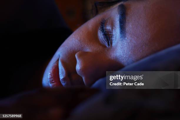 young woman asleep in bed - sleeping woman stock pictures, royalty-free photos & images