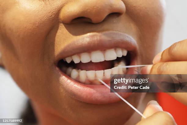 woman flossing teeth - bad breath stock pictures, royalty-free photos & images