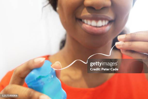 woman flossing teeth - gingivitis stock-fotos und bilder