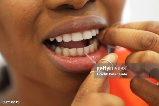 woman flossing teeth - gingivitis stock-fotos und bilder