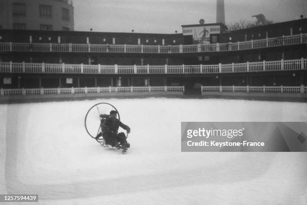 Inventeur faisant la demonstration de son véhicule à propulsion à hélice sur glace, sur la piscine Molitor gelée, à Paris, le 26 décembre 1936,...