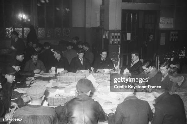 Centre de tri postal submergé de cartes de voeux et de cadeaux lors des fêtes de fin d'années, le 31 décembre 1936, France.