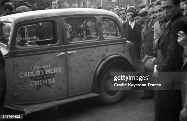 Voiture de m'Armée populaire de la République espagnole criblée de balles de retour du front, à Barcelone, pendant la guerre d'Espagne, en décembre...