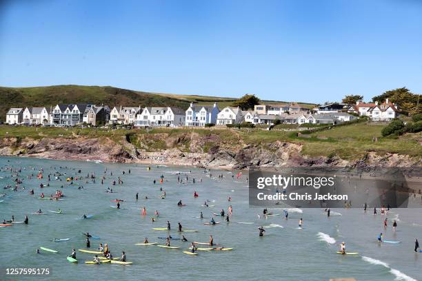 Beachgoers enjoy Polzeath beach on July 21, 2020 in Polzeath, United Kingdom. Many UK residents have decided to go on 'staycations' to Devon and...