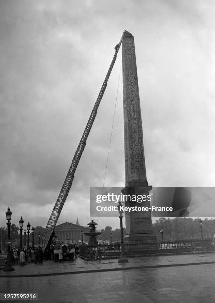 Escalade de l'obélisque de la place de la Concorde avec la grande échelle des pompiers par Mario Fabre, jeune camelot se faisant passer pour un...