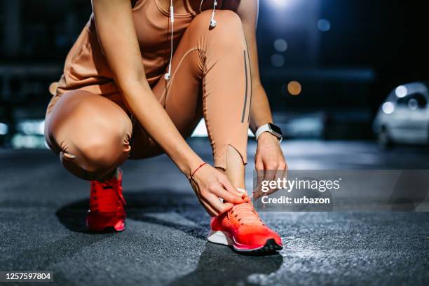 tying shoelace on running shoes before practice - racing garage stock pictures, royalty-free photos & images