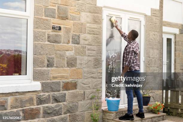 jeunes hommes nettoyant les fenêtres de porte de patio - porte d'accès à la terrasse photos et images de collection