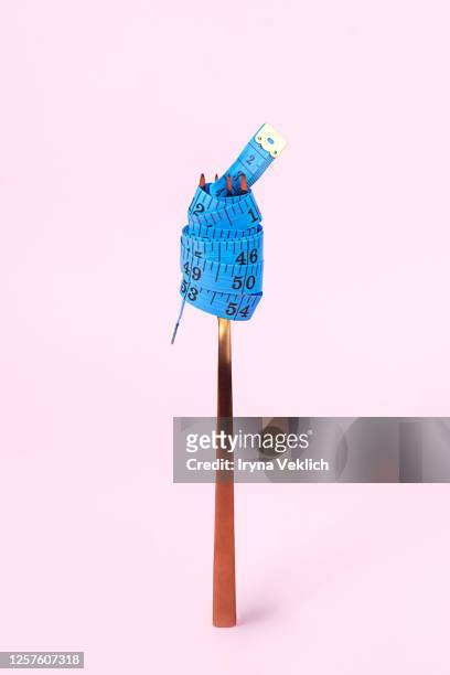 blue measuring tape and fork on pink background. - fat loss stock-fotos und bilder