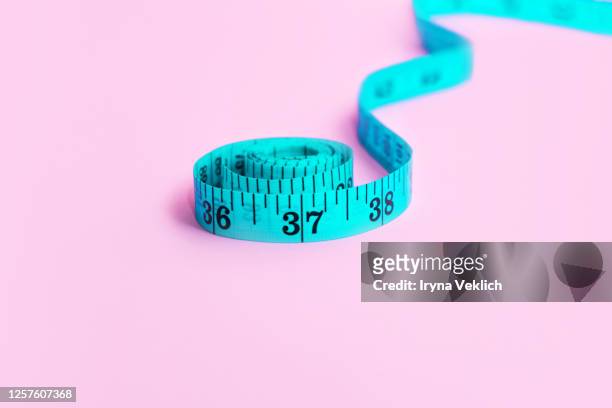 blue measuring tape on pink background. - measuring tape foto e immagini stock