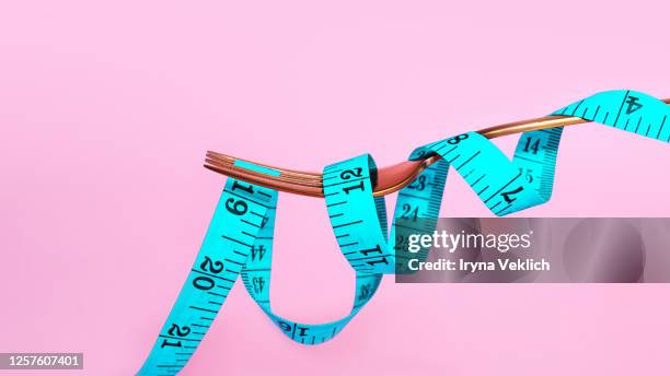 blue measuring tape and fork on pink background. - loose stock pictures, royalty-free photos & images