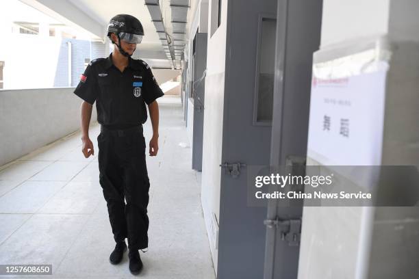 Security guard wears a smart helmet equipped with a thermo-scan sensor to check the body temperature during an exam at a middle school on July 22,...