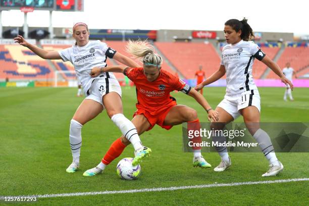 Rachel Daly of Houston Dash looks for the ball against Morgan Weaver and Raquel Rodriguez of Portland Thorns FC during the first half in the...